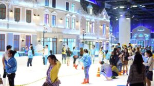 Khung cảnh bên trong Snow Town Quận 2 với khách tham quan chơi tuyết nhân tạo, mặc áo ấm và ủng