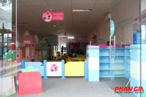 Lối vào khu vui chơi Dâu Tây (Đồng Tháp) với hàng rào pastel, tủ kệ xanh và nhà chơi mini
