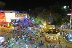 Khu vui chơi ngoài trời ban đêm ở Quận 4 với vòng quay ngựa, trò chơi quay, tàu lắc và quầy hàng