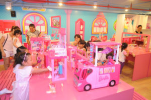 Các bé chơi trong góc trò chơi màu hồng tại TiniWorld Flagship với xe đồ chơi Barbie và phụ huynh quan sát