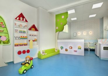 Phòng học mầm non hiện đại với bàn ghế gỗ nhỏ và kệ đồ chơi gọn gàng