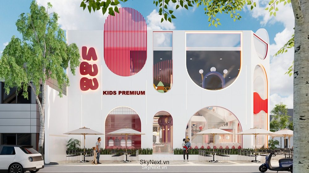 Mặt tiền tòa nhà trắng với cửa vòm, logo 'KIDS PREMIUM' và sân ngoài trời