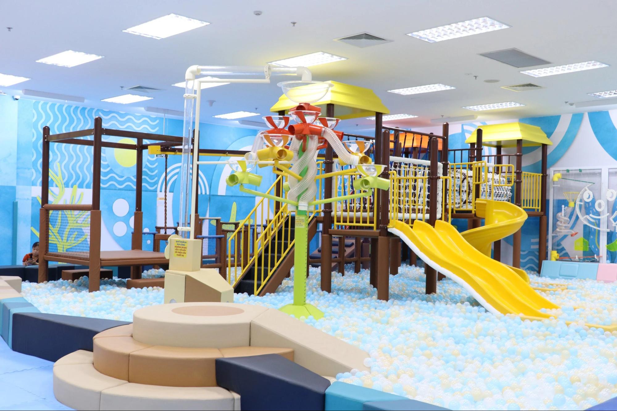 Bố mẹ và trẻ em vui chơi trong khu vui chơi trong nhà