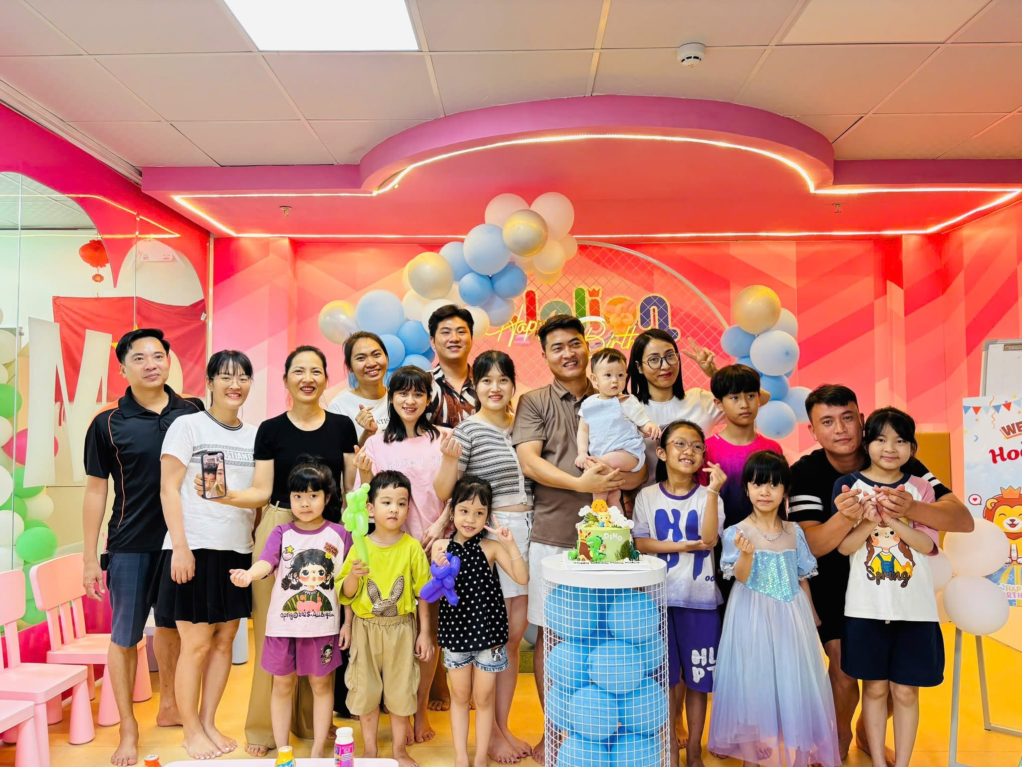 Gia đình và trẻ em chụp ảnh bên bánh sinh nhật trong phòng tiệc khu vui chơi